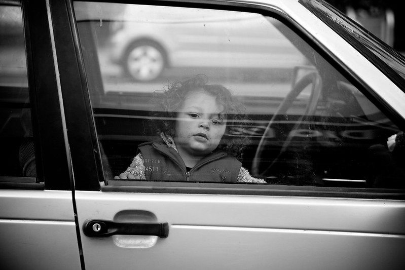 Kind in auto achter raam wachten ouders vroeger
